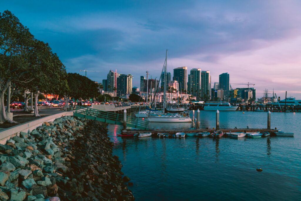 Twilight photo of San Diego marina with skyline and docked boats, capturing urban tranquility.