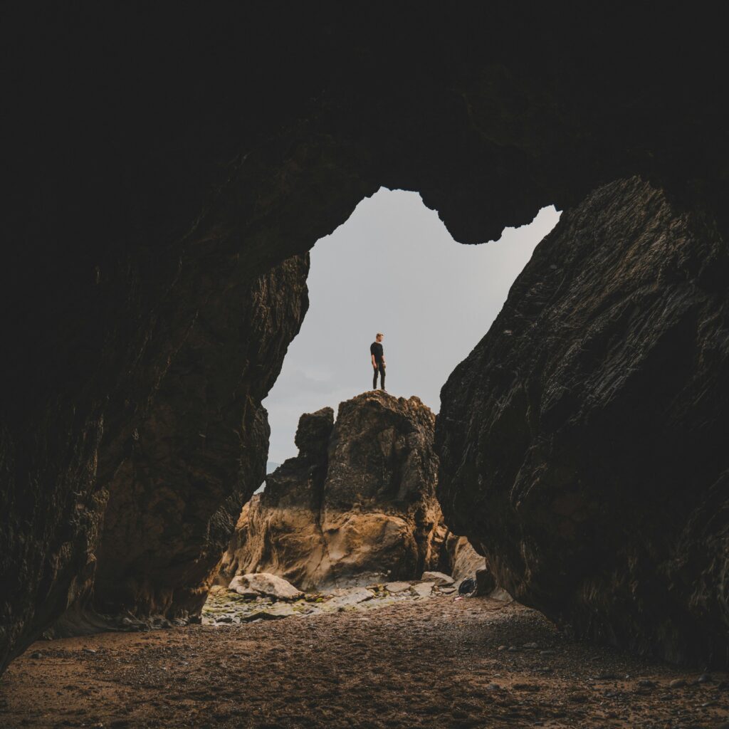 Silhouette of a man standing on a rock formation inside a cave, Dublin, Ireland.